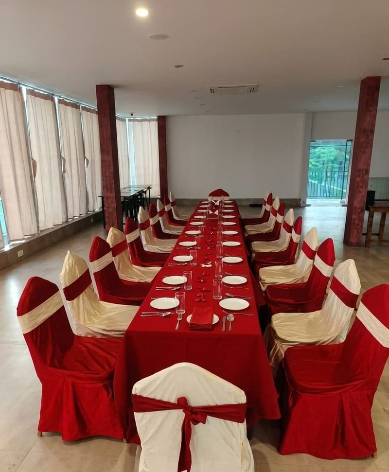 Banquet chairs dressed in cream and red sashes