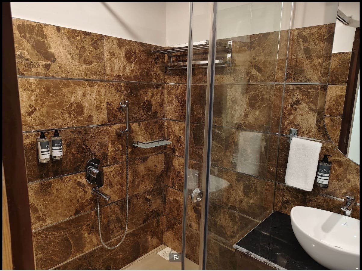 A marble bathroom with a walk-in shower