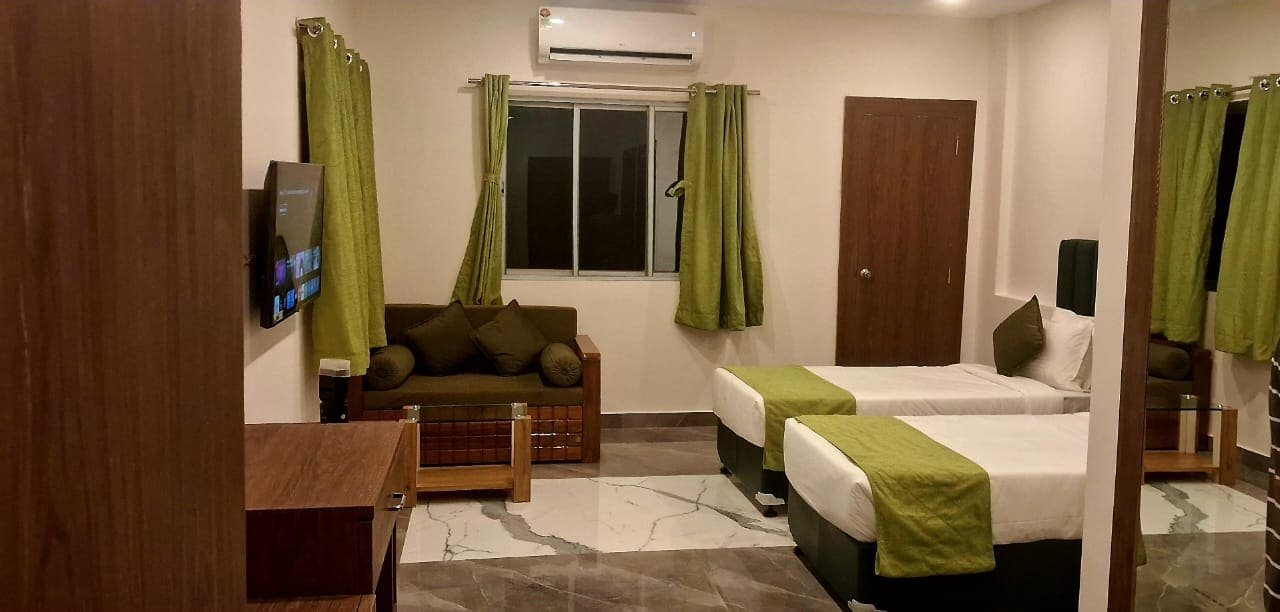 Super deluxe room laid out with two beds and a seating corner