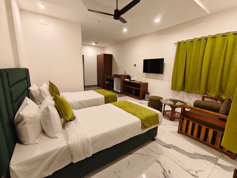 Two beds with a television and cabinet along the wall