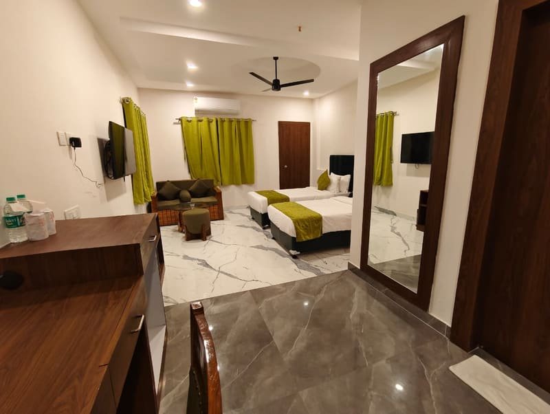 A room with a full-length mirror reflecting the beds